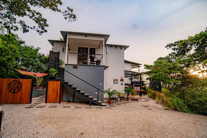 Villa Alegria at dusk — the two-story white villa framed by trees
