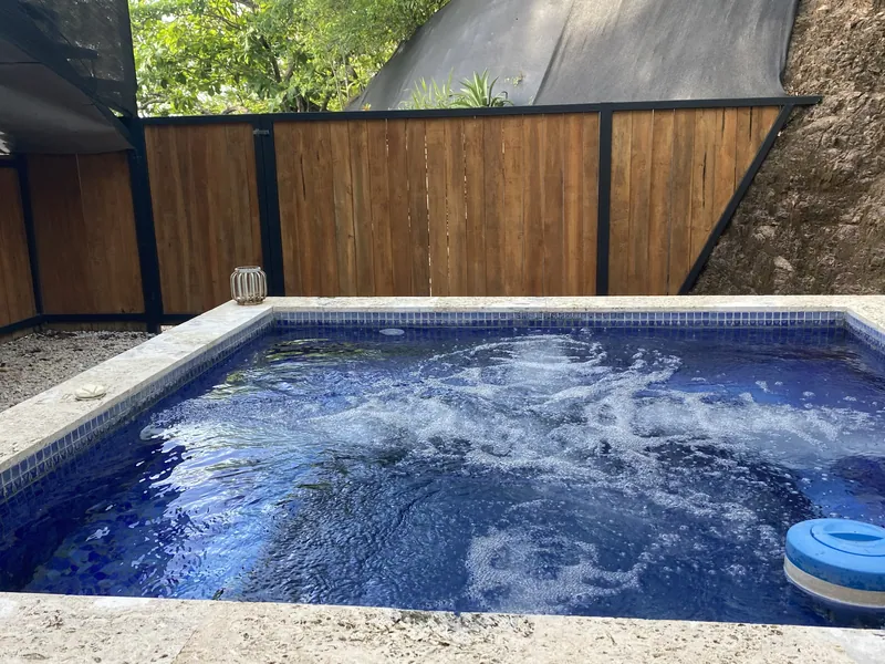 The private plunge pool at Villa Luna with the jets running, wrapped in a teak privacy fence
