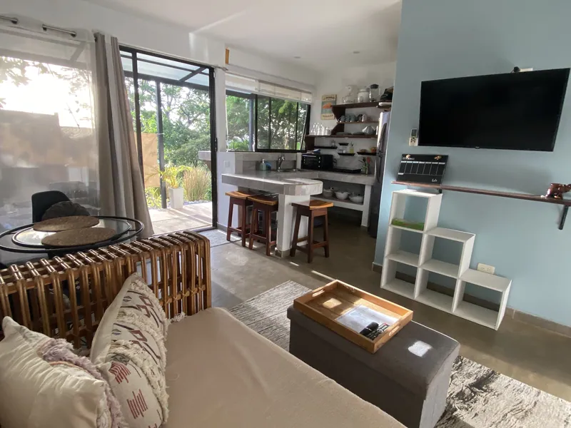 The open-plan living room and kitchen at Villa Luna, the breakfast bar and sliding doors opening to the garden