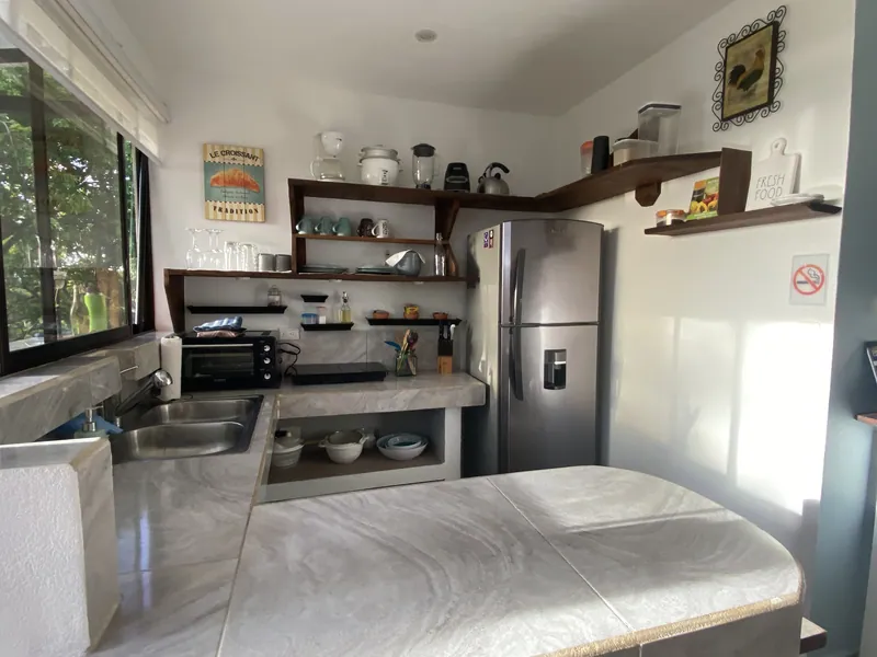 The kitchen at Villa Luna, marble counters, open shelving and a stainless steel refrigerator