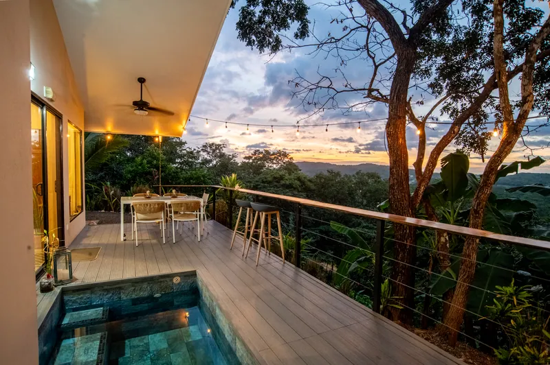 The covered deck at Villa Lunax at dusk, its plunge pool set above the jungle valley