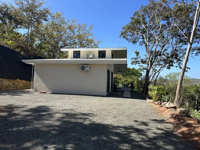 The clean white lines of Villa Lunax seen from its motor court under a clear sky