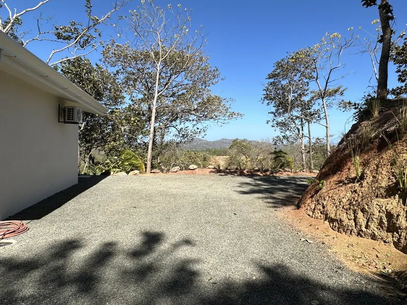 The side yard at Villa Lunax opening to distant mountains and dry-forest hills