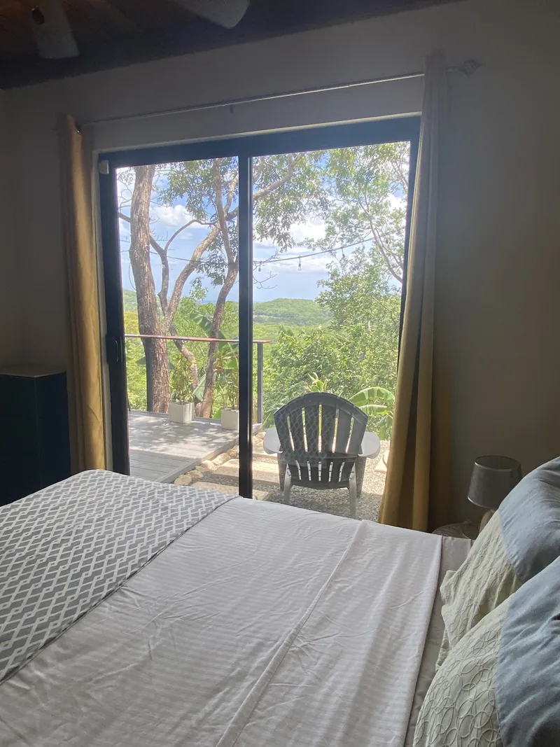 Morning light through the second bedroom's sliding doors at Villa Lunax, terrace and jungle beyond