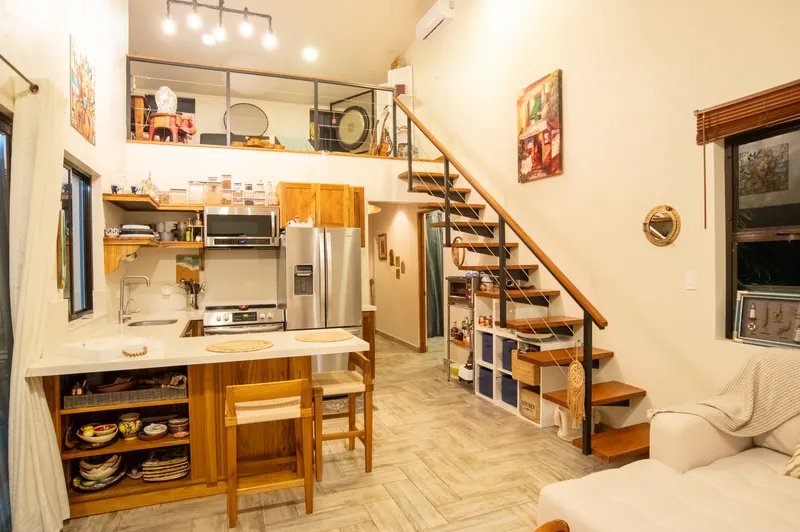 The double-height great room at Villa Lunax, kitchen below and the teak loft above