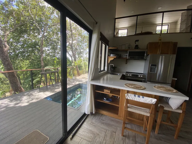 The kitchen and breakfast bar at Villa Lunax, sliding glass framing the plunge pool