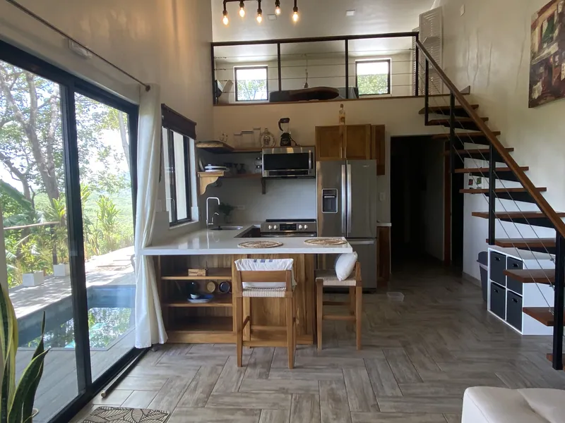The great room at Villa Lunax, kitchen and loft framed by sliding doors to the pool