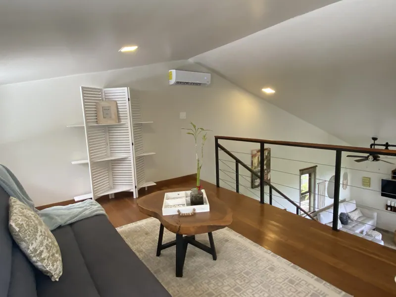 The loft sitting area at Villa Lunax, sofa and coffee table under the pitched roof