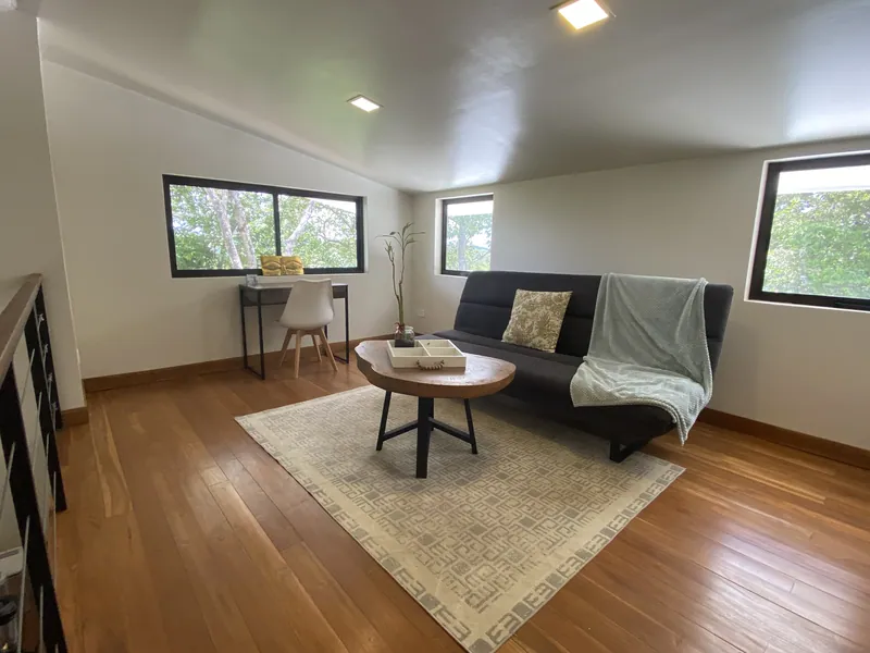 The bright loft retreat at Villa Lunax, a daybed and desk between treetop windows