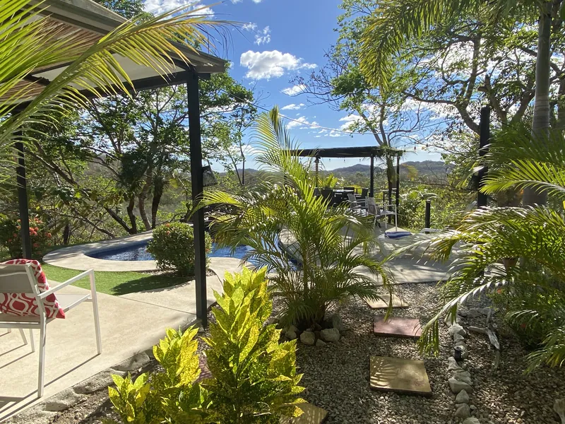 The garden path and pool winding toward the dining pergola at Villa Sol