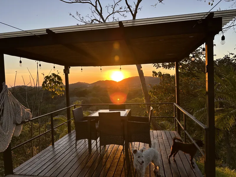 Sunset over the hills seen from the pergola deck at Villa Sol, with the resident dogs