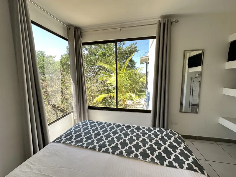 A ground-floor bedroom at Villa Sol with corner windows onto the garden