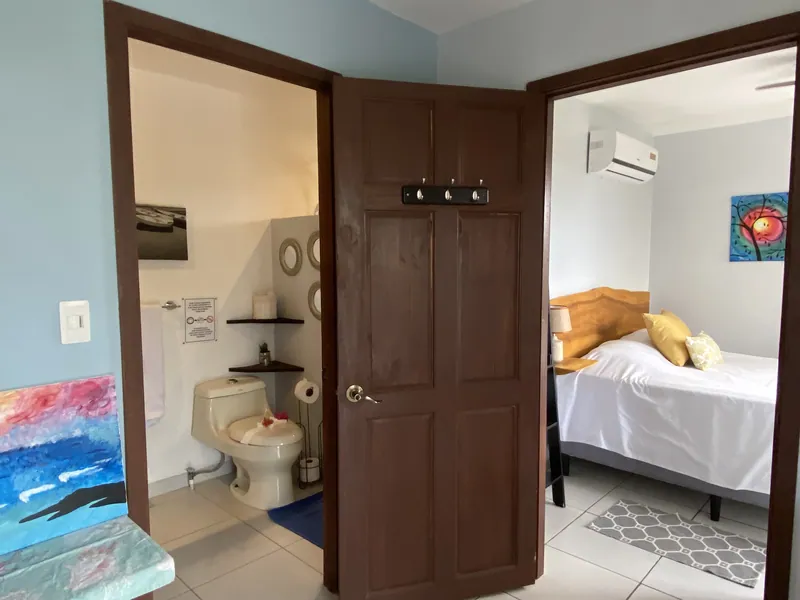 The upstairs bedroom and ensuite bathroom at Villa Sol seen through the doorway