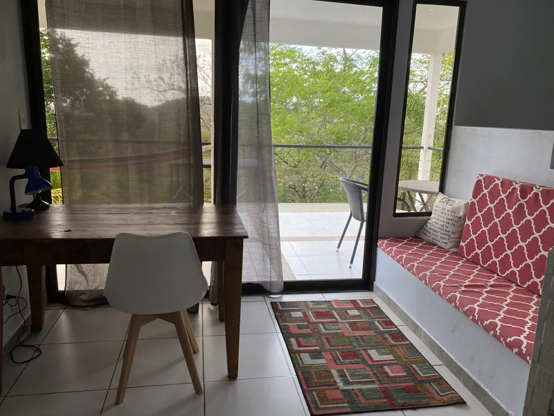 The upstairs study nook at Villa Sol with a desk and daybed beside the balcony