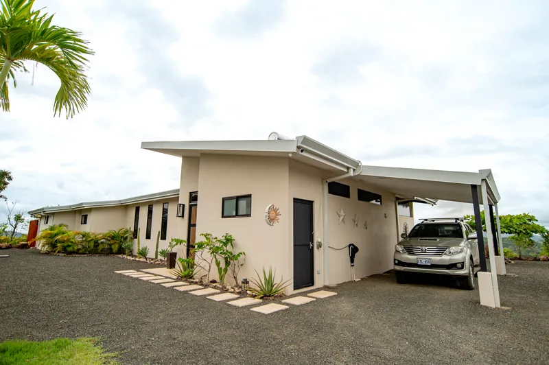 The entrance and carport of Villa Toltec under a soft, cloudy sky