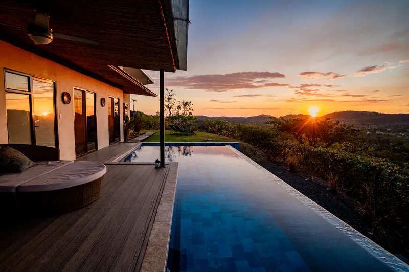 The infinity pool mirroring a fiery sunset over the mountains