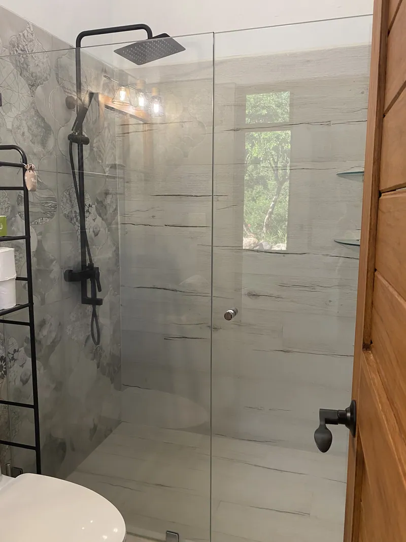 The walk-in rain shower with a window onto the greenery outside