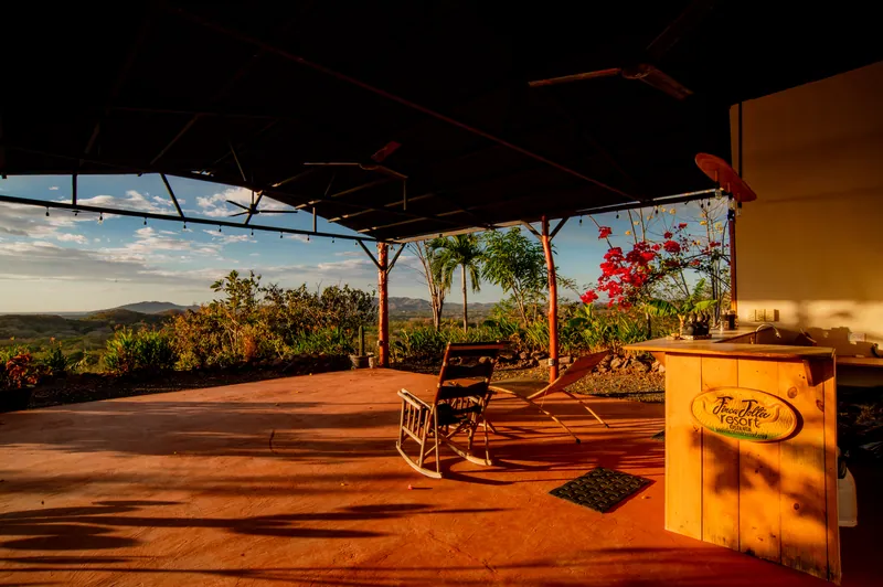 Inside the open-air yoga studio, rocking chairs facing the hills at sunset