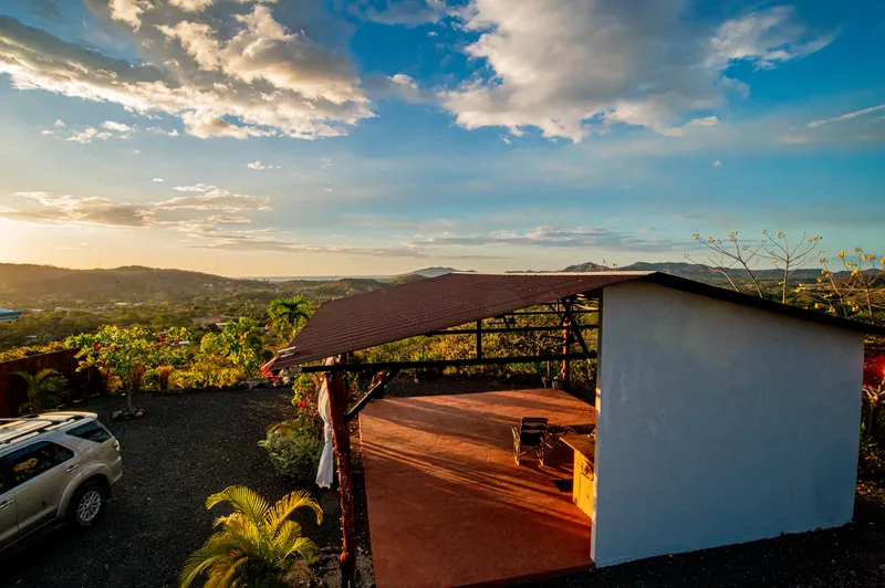 The yoga studio pavilion on its hilltop, the coastline stretching out at dusk