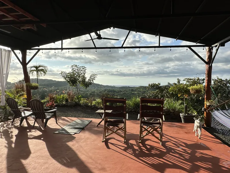 Rocking chairs and a hammock under the yoga studio roof, the ocean in the distance