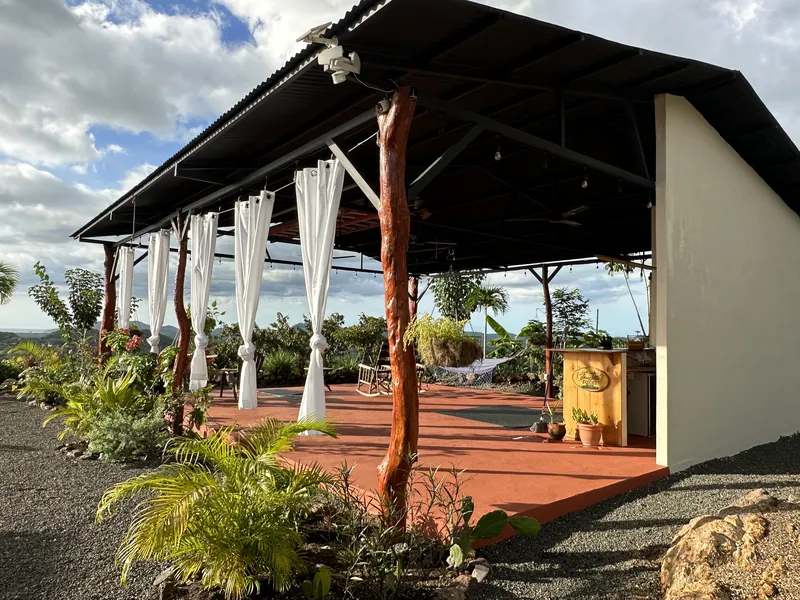 The yoga studio pavilion with curtains, a bar and tropical planting